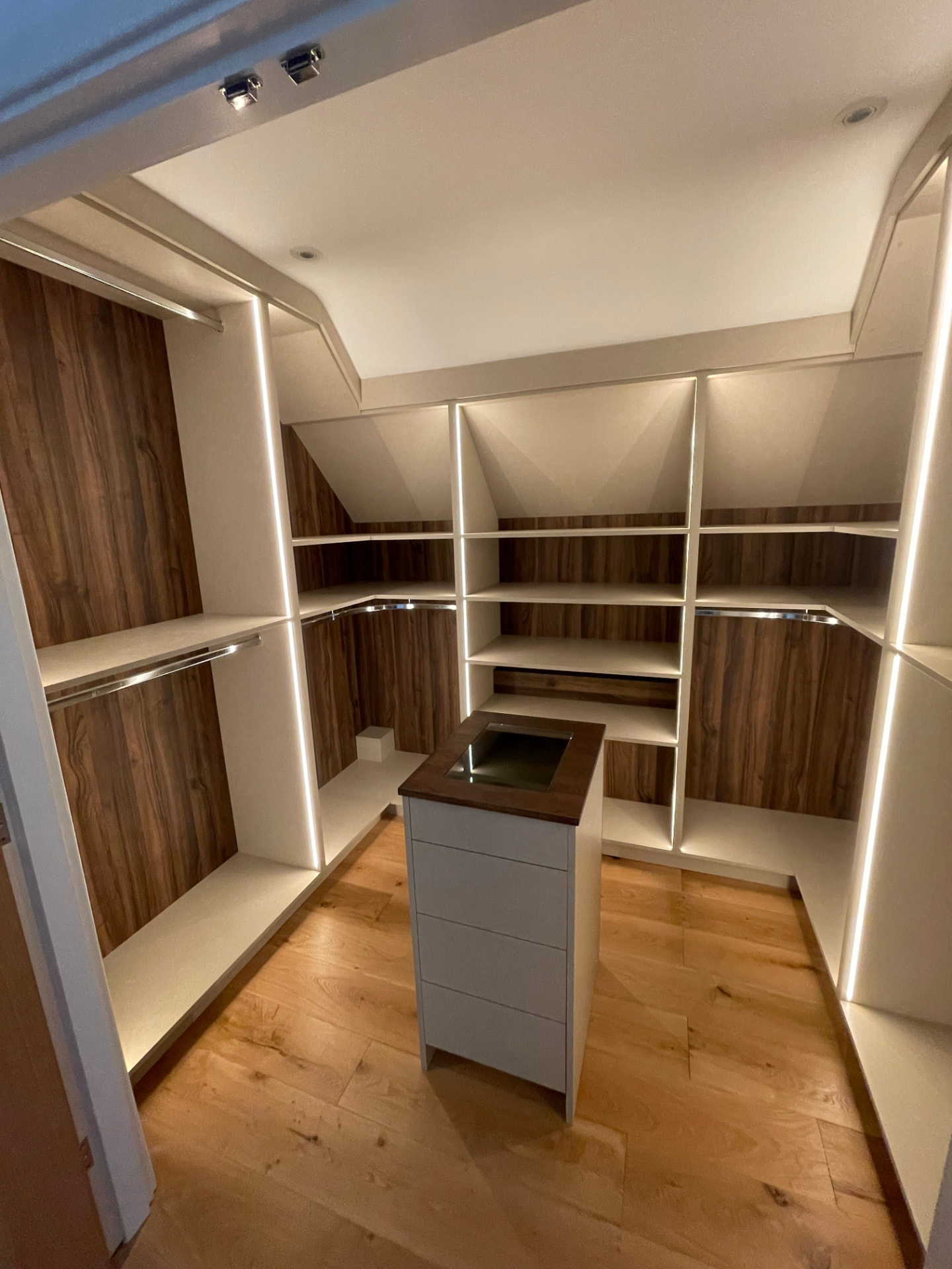 Bespoke walk-in wardrobe with walnut interiors and integrated lighting