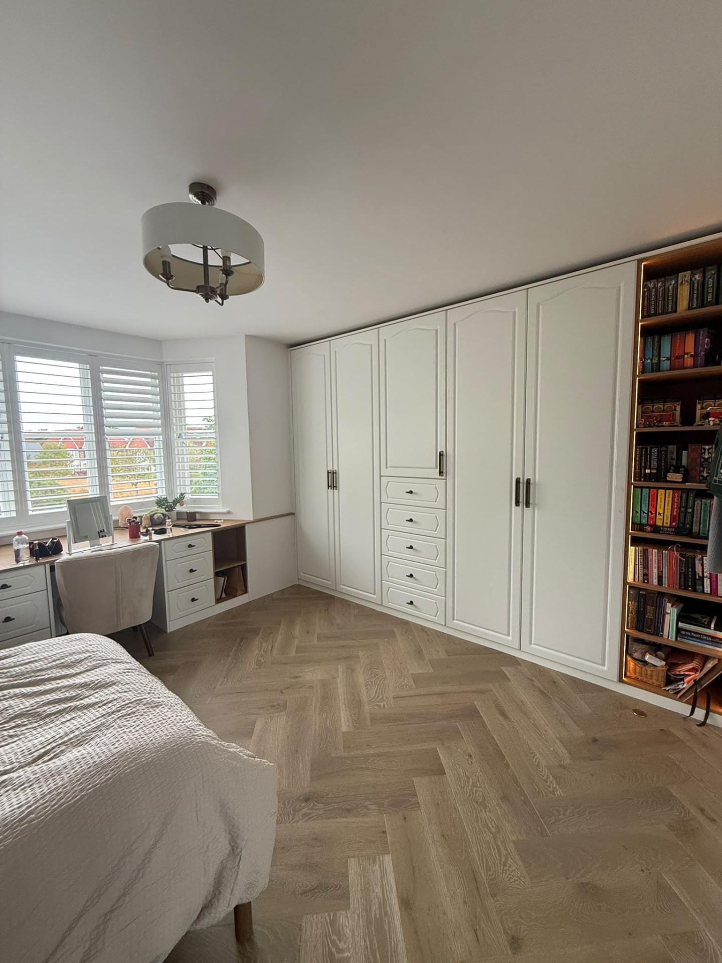 White fitted bedroom wardrobes with drawers, desk and illuminated bookcase